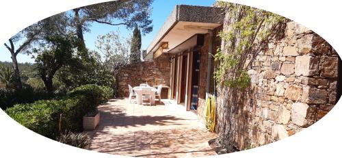 un bâtiment en pierre avec une table et des chaises sur une terrasse dans l'établissement VILLA ALPASA - Boulouris AIGUEBONNE, Villa vue mer dans domaine 5 min à pied de la plage, à Saint-Raphaël
