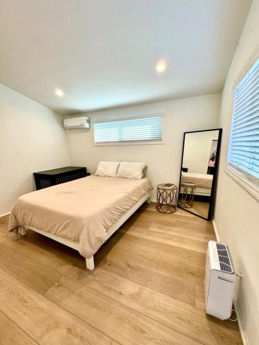 a bedroom with a bed and a mirror in it at Heart of Corona Del Mar 10 minute walk to beach steps to downtown in Newport Beach