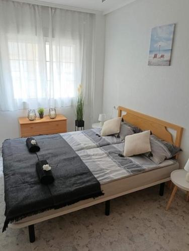 a bedroom with a large bed with a black blanket at Sandy Home - Élvezd a tengerpartot! in La Mata
