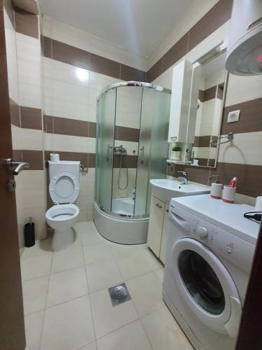 a bathroom with a toilet and a washing machine at Astra Apartman Nikšić in Nikšić