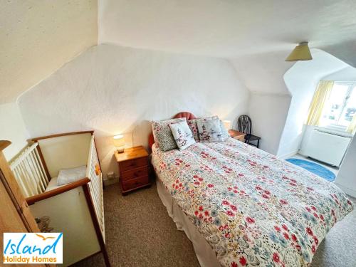 a bedroom with a bed with a floral bedspread at St Catherines View in Ventnor