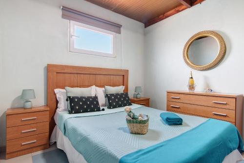 Un dormitorio con una cama con una cesta de flores. en Playa del Hombre, en Playa del Hombre