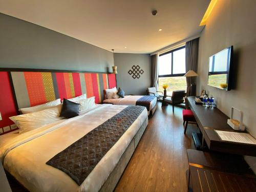 Habitación de hotel con cama grande y escritorio. en APEC Mandala Cham Bay Mũi Né en Ấp Thiẹn Ái