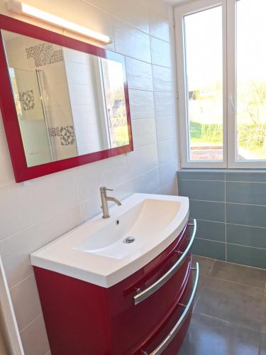 bagno con lavandino e specchio di Gite Le Pigeonnier a Miers
