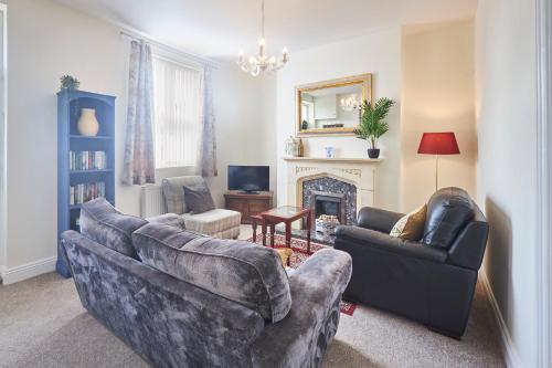 sala de estar con 2 sofás y chimenea en Cosy and convenient cottage en Bishop Auckland