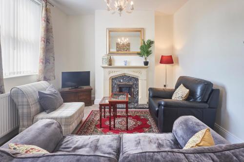 a living room with a couch and a fireplace at Cosy and convenient cottage in Bishop Auckland