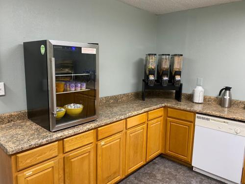 a kitchen with a counter with a refrigerator at Days Inn & Suites by Wyndham Springfield on I-44 in Springfield