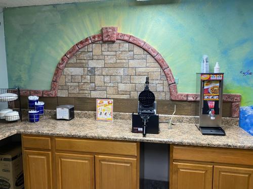 a kitchen with a counter with a brick wall at Days Inn & Suites by Wyndham Springfield on I-44 in Springfield