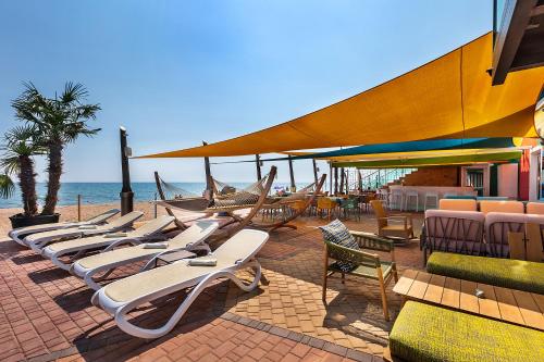 a row of lounge chairs and umbrellas on the beach at UnderSun Spa Hotel in Gribovka