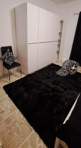 a living room with a black rug and a chair at The Palm Villa in St Paul's Bay