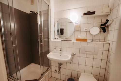 a bathroom with a sink and a shower at Hotel Garni "Villa am Schaalsee" in Zarrentin