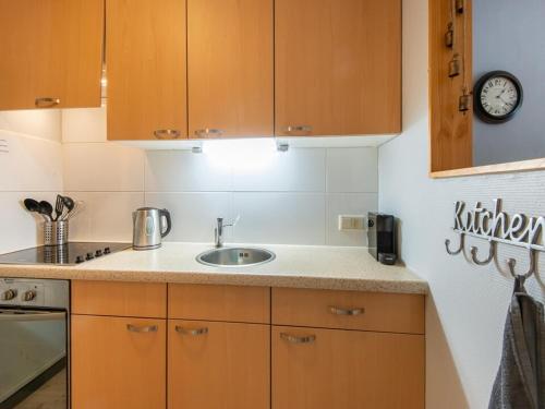 a kitchen with a sink and a clock on the wall at SkiJuwel Appartments Auffach - Wildschönau - Tirol in Auffach