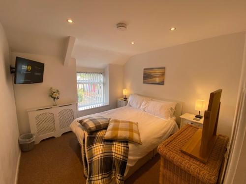 a bedroom with a bed and a television in it at The Cwtch, Log Fire, Sleeps 5, Nr Zip World, Brecon and Bike Park Wales in Aberdare