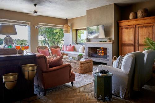 a living room filled with furniture and a fireplace at Ukuthula House in Hectorspruit