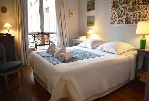 - une chambre avec un grand lit blanc et des serviettes dans l'établissement Montparnasse - Palace, à Paris