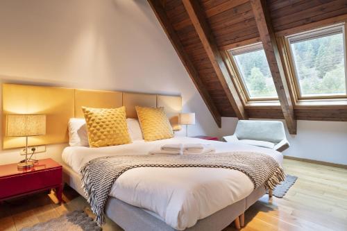 - une chambre avec un grand lit et 2 fenêtres dans l'établissement Luderna - Casa Val de Ruda II, à Baqueira-Beret