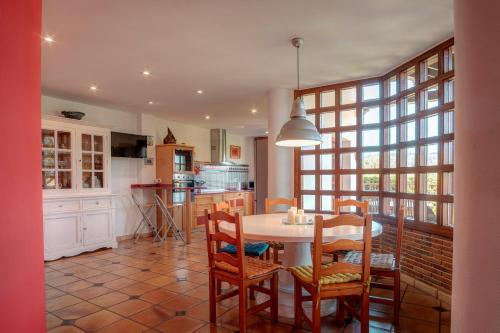 a kitchen and dining room with a table and chairs at Casa La Serena in Lusa