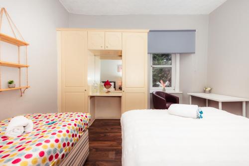 - une chambre avec deux lits, une chaise et une fenêtre dans l'établissement Warm&Welcoming City Centre Apartments by Meadows 8, à Édimbourg