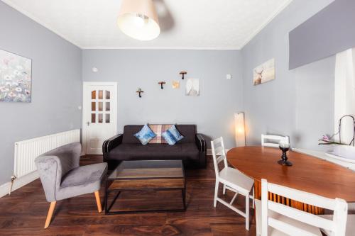 - un salon avec une table et un canapé dans l'établissement Warm&Welcoming City Centre Apartments by Meadows 8, à Édimbourg