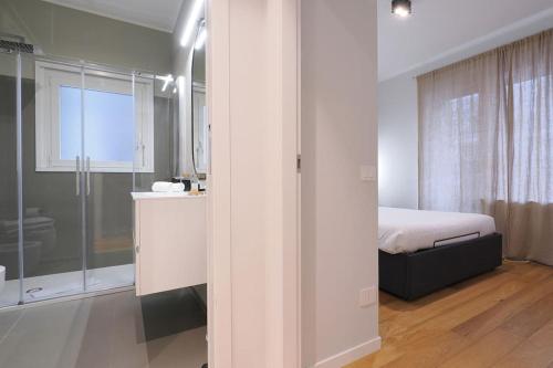 een witte slaapkamer met een bed en een douche bij Contempora Apartments - Elvezia 8 - E43 in Milaan