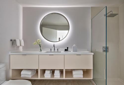 Baño blanco con lavabo y espejo en Hotel AKA Washington Circle, en Washington
