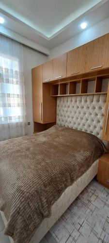 een slaapkamer met een groot bed en houten kasten bij Goygol House in Aşıqlı