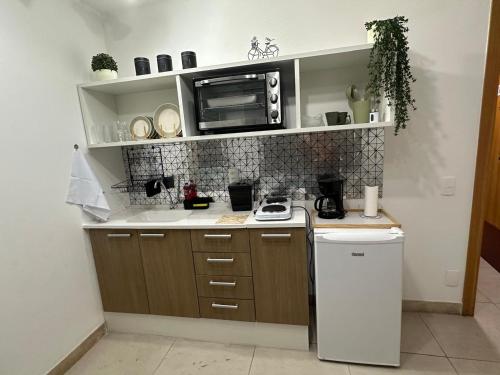 a small kitchen with a microwave and a stove at Casa Mauá 312 in Rio de Janeiro