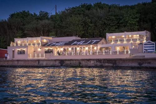 a building on a dock next to a body of water at 107 Brambles Chine, Holiday Coastal Chalet in Freshwater