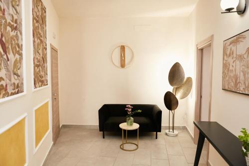 a living room with a black couch and a table at Casa Altarocca - Home Design in Tarquinia