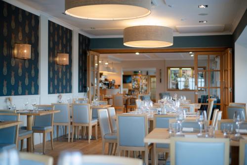 a dining room filled with tables and chairs at Trevose Golf and Country Club in Padstow