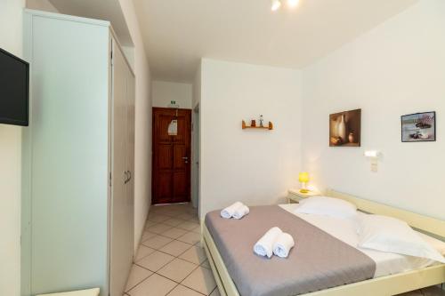 1 dormitorio con 1 cama con toallas en Froudi Rooms, en Kamarai