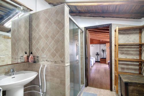 uma casa de banho com um lavatório e uma cabina de duche em vidro. em Quinta Alegre em Porches