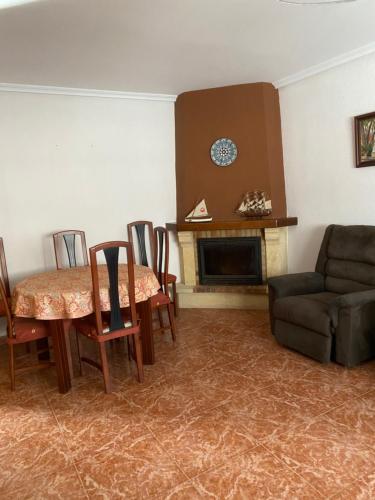 een woonkamer met een tafel en stoelen en een open haard bij 1era linea de playa Cullera Villa Sales in Cullera