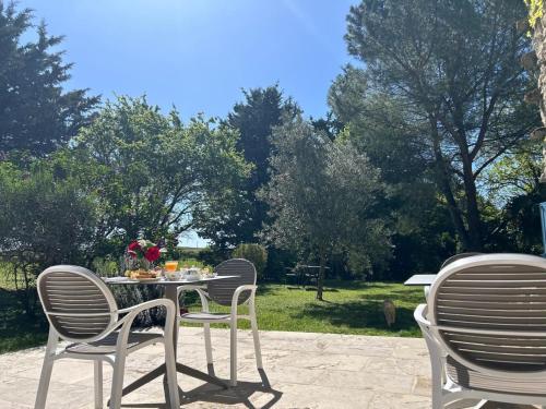 een tafel en stoelen op een patio met bomen bij LE CLOS PASTEL Chambres d'hôtes & Gite in Virac