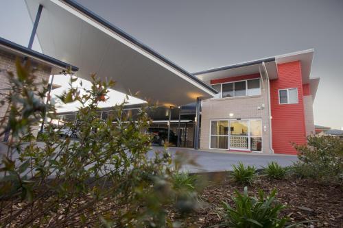 a building with a red door and a garage at Altitude Motel Apartments in Toowoomba