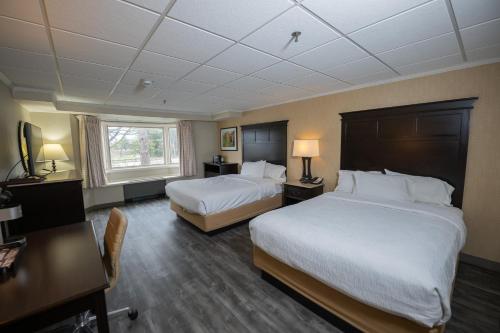 a hotel room with two beds and a desk at Peek'n Peak Resort Trademark Collection by Wyndham in Clymer