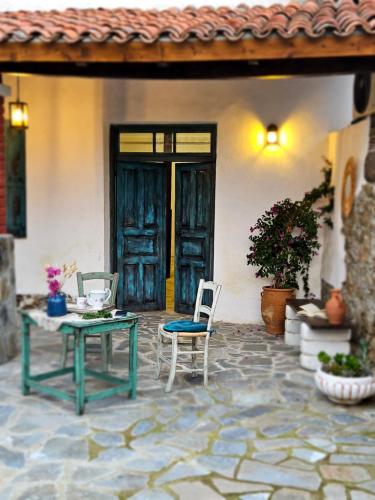a patio with two chairs and a table in front of a house at Traditional adobe house in Evrychou with cozy garden and fireplace! in Nicosia