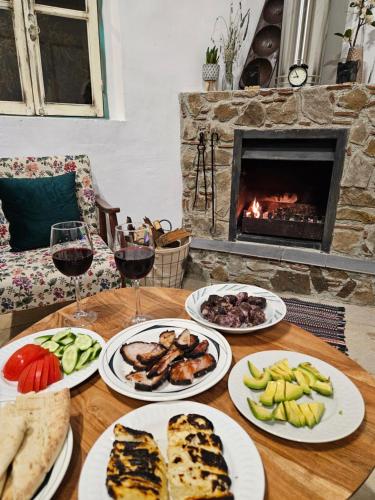 a table with plates of food and glasses of wine at Traditional adobe house in Evrychou with cozy garden and fireplace! in Nicosia