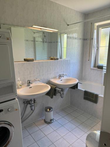 een badkamer met 2 wastafels en een bad bij Ferienwohnung Gary mit zwei Terrassen und Garten in Garmisch-Partenkirchen