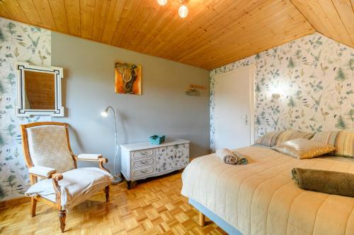 1 dormitorio con 1 cama y 1 silla en Gîte en montagne vosges alsaciennes, en Fréland