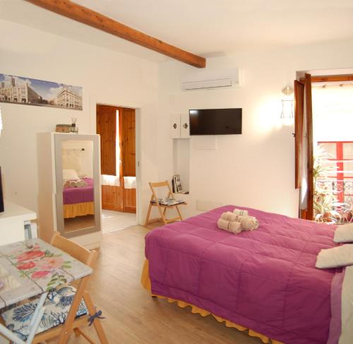 ein Schlafzimmer mit einem lila Bett und einem Tisch in der Unterkunft Alla Marina in Cagliari