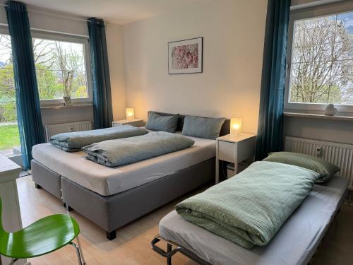 twee bedden in een kamer met twee ramen bij Ferienwohnung Gary mit zwei Terrassen und Garten in Garmisch-Partenkirchen
