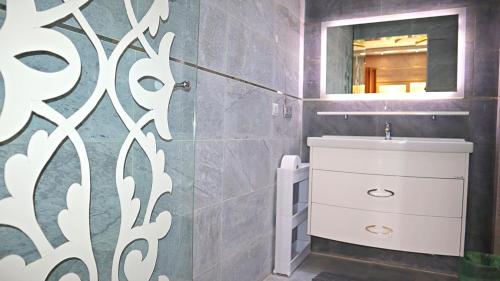 a bathroom with a white sink and a mirror at Barthélemy Guest House in Marrakech