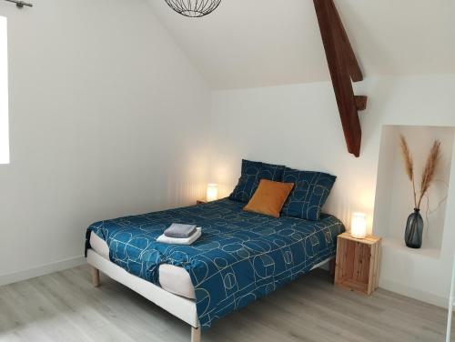 1 dormitorio con 1 cama con sábanas azules y almohadas de color naranja en La Villa Coudray - Au Calme - Spacieuse, en Chavagne