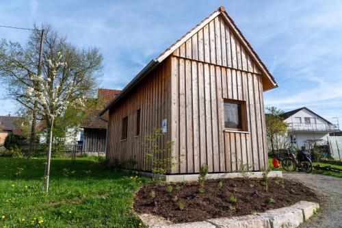 a small wooden house in a yard with a tree at Tinyhaus am Bussen in Unlingen