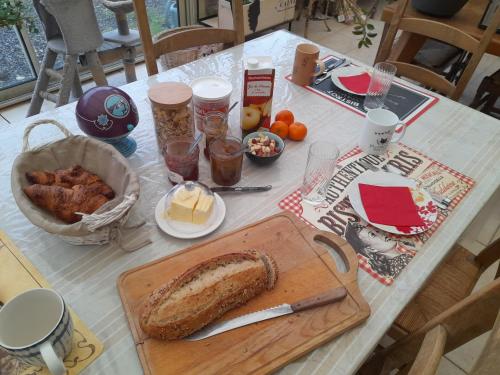 Una mesa con una hogaza de pan y comida sobre ella. en Au Moulin de la Tour, en La Malmaison