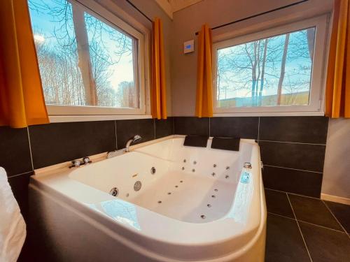 - Baño con bañera y 2 ventanas en Privátní wellness domek RockStar, en Smržovka