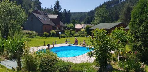 a group of people sitting around a swimming pool at Podskalí Adršpach in Teplice nad Metují