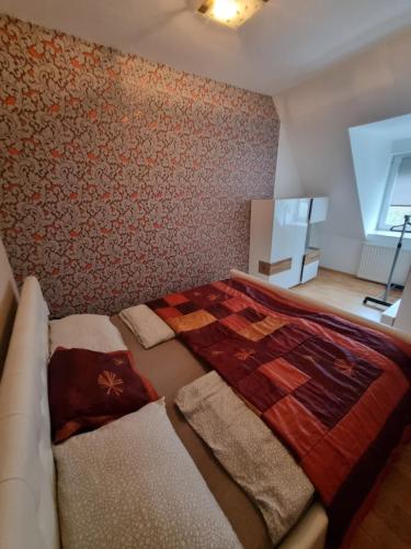 a bedroom with a bed with a comforter on it at Sarok Villa in Siófok