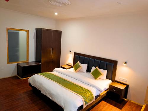 a bedroom with a large bed and a mirror at Apricuss hotel in Leh